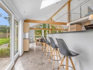 a kitchen and dining room with a bar with stools at Holiday Home Talitha - 40m from the sea by Interhome in Marielyst