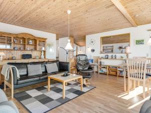 a living room with a couch and a table at Holiday Home Senni - 800m from the sea by Interhome in Rønsheved +13 photos