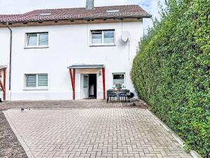 a white house with a table in front of it at Apartment Sonnenblick by Interhome in Amelunxen
