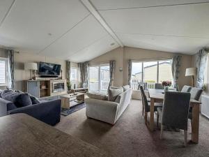 ein großes Wohnzimmer mit einem Tisch und Stühlen in der Unterkunft Stunning Lodge At Seaview Holiday Park In Kent Ref 47012Pb in Whitstable
