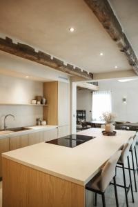 an open kitchen with a large island with stools at Maison Aimée Cottage 9 people in Rochefort
