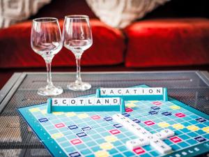 ドラムナドロッキットにあるHoliday Home Highland View by Interhomeのテーブルの上にはワイングラス2つとボードゲームが置かれている