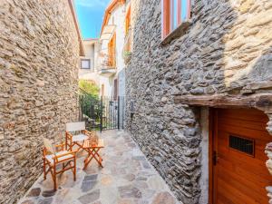 une ruelle pavée avec deux chaises et une table dans l'établissement Holiday Home Stone House by Interhome, à Gera Lario