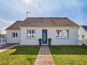 a white house with a blue door at Holiday Home Maison Edgar Luce by Interhome in Agon Coutainville
