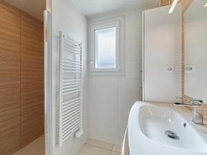 a white bathroom with a sink and a window at Holiday Home Maison Edgar Luce by Interhome in Agon Coutainville