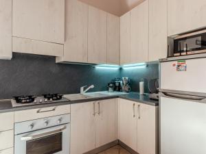 une cuisine avec des armoires blanches, un évier et un réfrigérateur dans l'établissement Holiday Home Stone House by Interhome, à Gera Lario 23 autres photos