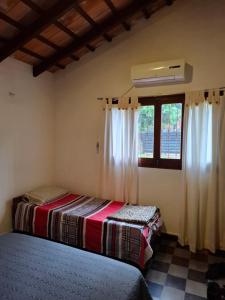 two beds in a room with a window at Casa Encarnación in Encarnación