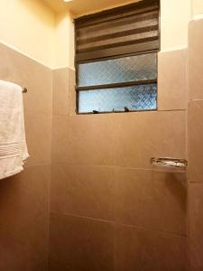 a bathroom with a shower and a window at 1&2&3bedroom KlenCBDMilimani apartments in Kisumu
