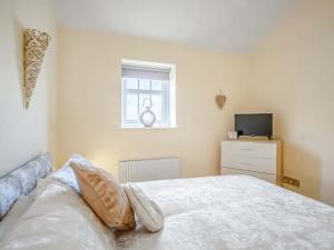 ein Schlafzimmer mit einem Bett und einem Fenster und einem Fernseher in der Unterkunft Peewit Cottage-Ukc6986 in Castleside