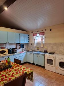 a kitchen with white cabinets and a table with a tableablish at Casa Encarnación in Encarnación