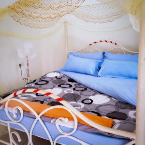 ein Schlafzimmer mit einem Bett mit blauen Kissen in der Unterkunft Arien Hotel in Hoima + 25 Fotos