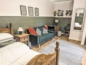 ドラムナドロッキットにあるHoliday Home Highland Garden Room by Interhomeのベッドルーム(緑のソファ、ベッド付)