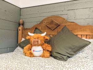 ドラムナドロッキットにあるHoliday Home Highland Garden Room by Interhomeの枕付きベッドに座るぬいぐるみ