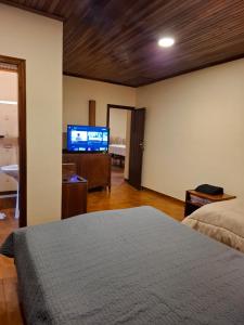 a bedroom with a bed and a flat screen tv at Casa Encarnación in Encarnación