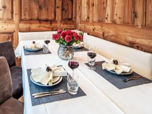 a table with glasses of wine and a vase of flowers at Apartment Chesa Spuonda Verde 2-5 by Interhome in St. Moritz +23 photos