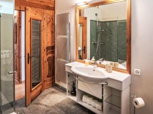 a bathroom with a sink and a shower and a mirror at Apartment Chesa Spuonda Verde 2-5 by Interhome in St. Moritz