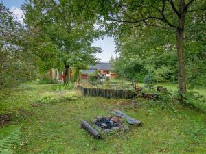 a pile of logs in the grass in front of a house at Holiday Home Elea - 450m to the fjord by Interhome in Skalstrup