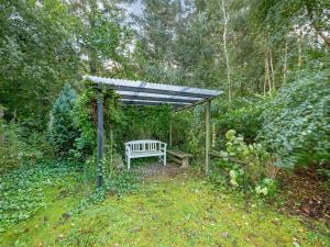 a bench under a pergola in a garden at Holiday Home Elea - 450m to the fjord by Interhome in Skalstrup