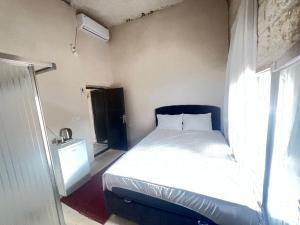 ein kleines Schlafzimmer mit einem Bett und einem Fenster in der Unterkunft Mareda house in Midyat