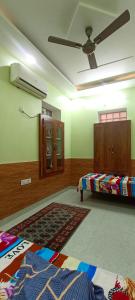 a bedroom with two beds and a ceiling fan at Rajawat house in Tonk City +3 photos