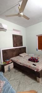 a bedroom with a bed and a ceiling fan at Rajawat house in Tonk City
