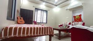 a bedroom with a bed and a guitar on the wall at Rajawat house in Tonk City