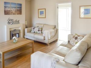 un soggiorno con un divano e un tavolo di Seagull Cottage a Portreath