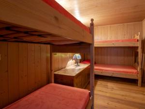 a room with two bunk beds and a table at Apartment Pozzaglio Mountain Home by Interhome in Valdisotto