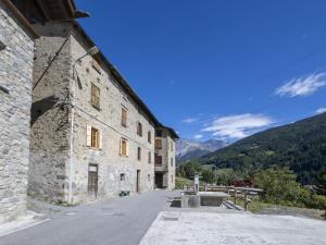 an old stone building with mountains in the background at Apartment Pozzaglio Mountain Home by Interhome in Valdisotto