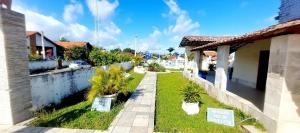 a house with a yard with palm trees in it at Cond CHACARA BAVIERA in Gravatá