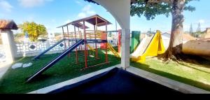 a playground with a slide and a tree at Cond CHACARA BAVIERA in Gravatá