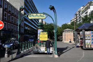 a street sign on a pole on a city street at Hôtel Sofiane in Paris