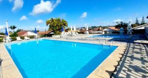 a swimming pool at a resort with blue water at Cond CHACARA BAVIERA in Gravatá