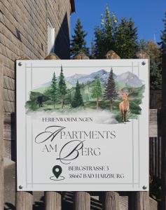 Un cartel en una valla con una señal para la entrada de un parque. en Apartments am Berg, en Bad Harzburg