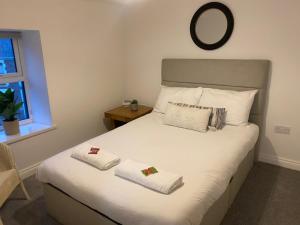 una camera da letto con un letto con due asciugamani sopra di Forest House by STAE-Homes a Port Talbot