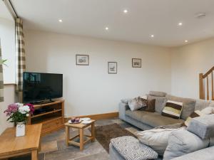 a living room with a couch and a flat screen tv at Applebarn - Uk10654 in West Pennard