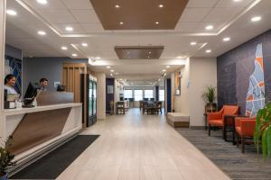 a lobby of an office with a woman at a counter at Holiday Inn Express Hotel & Suites Hampton South-Seabrook by IHG in Seabrook +45 photos