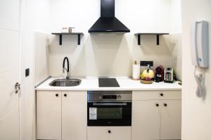 a small kitchen with a sink and a stove at Bernabéu Business & Stay in Madrid +71 photos