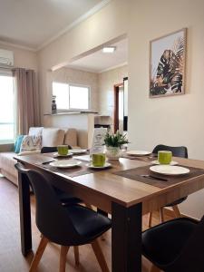 een eetkamer met een houten tafel en stoelen bij Apto lado Praia - Vista MAR in Praia Grande