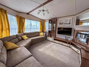 a living room with a couch and a flat screen tv at Superb Caravan At Steeple Bay Holiday Park In Essex, Sleeps 6 Ref 36081D in Southminster