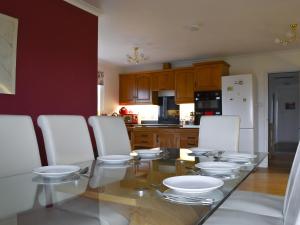 a kitchen with a glass table and white chairs at Fair View in Lairg
