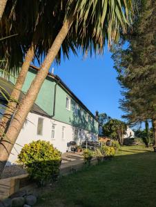 un edificio con palme di fronte di Ashdale Cottage with Sauna, Plunge Pool, Games Room, Kit Drying Room a Isle of Arran
