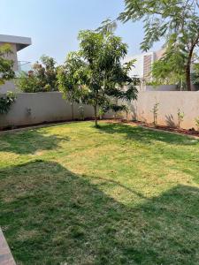 a garden with a tree in the middle of it at Luxury Villa with Private Garden in Dhamni