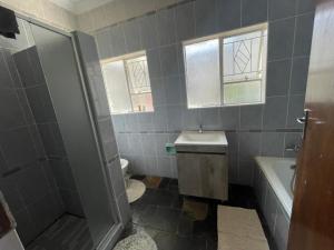 a bathroom with a shower and a sink and a toilet at Home Sweet Home in Vanderbijlpark +10 photos