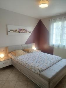 a bedroom with a bed with a purple wall at Gîte La Pointe de Diamant in Brigné