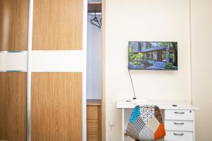 Una habitación con un escritorio y un televisor en la pared. en Amigo Suites, en Nairobi 4 fotos más