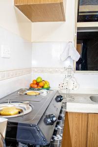 una cocina con fogones y un bol de fruta en Amigo Suites, en Nairobi