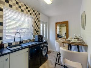 una cocina con fregadero y lavadora en Sunrise Cottage, en Berwick-Upon-Tweed