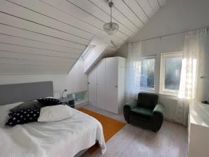 una camera da letto con un letto e una sedia verde di Scandinavian Villa with Sea Views Stockholm a Gustavsvik