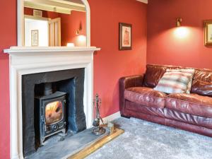 a living room with a couch and a fireplace at Oakwood Cottage - Glencoe in Glencoe